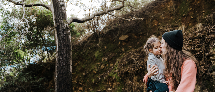 Mor og datter omfavner hinanden i skov