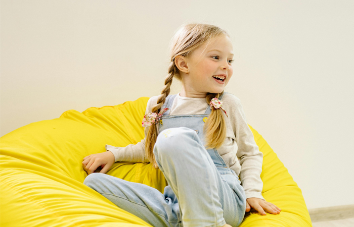 Pige i en gul sækkestol